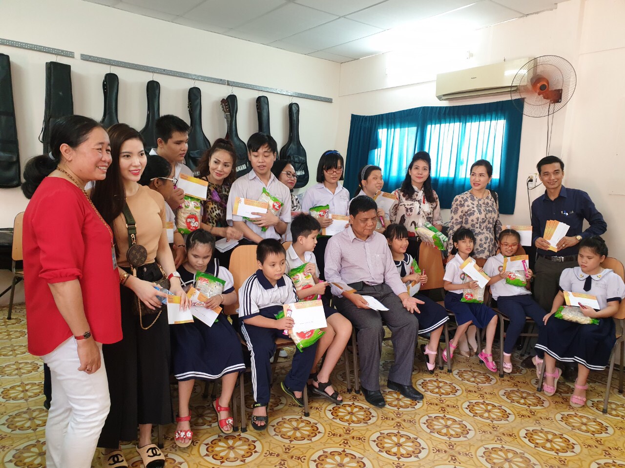 Cô Hà Thanh Vân (áo đỏ) – Hiệu trưởng trường PTĐB Nguyễn Đình Chiểu cùng một số doanh nghiệp trao học bổng cho 20 em có hoàn cảnh đặc biệt